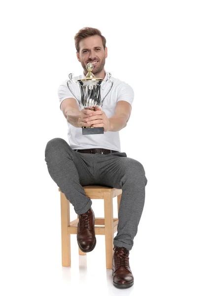 Gelukkig Zittende Man Biedt Een Trofee Witte Achtergrond — Stockfoto