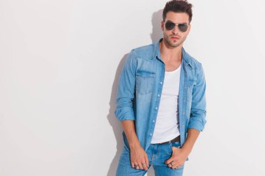 Çekici bir adam cebinde onun başparmak tutarak poz