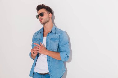 Çekici adam beyaz bir duvar bir Merhaba ayarlama karşı ayakta