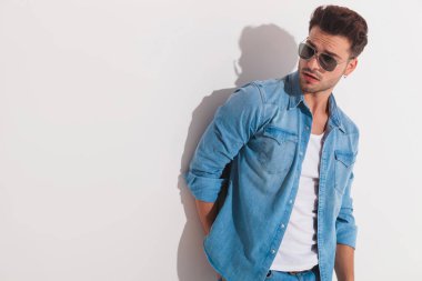 Duvara karşı duran ve bir yüzüne çekici adam