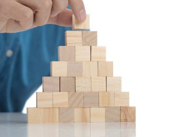 Casual giyimli adam ahşap bir tuğla bir kule üzerine yerleştirerek