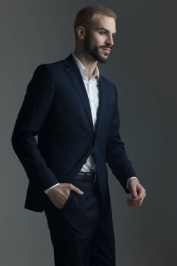 Elini cebine tutan takım elbiseli sarışın adam