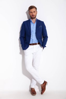 çekici bir adam smartcasual giysili bir duvara eğilir