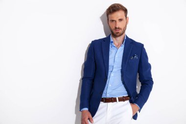 çekici bir adam smartcasual giysili bir duvara eğilir