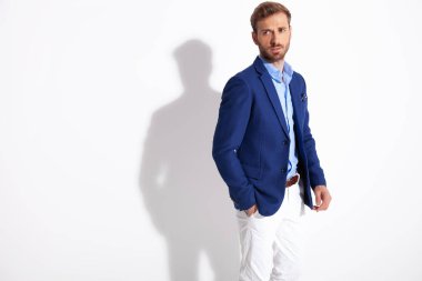 çekici bir adam el ile cebinde durur ve uzak görünüyor