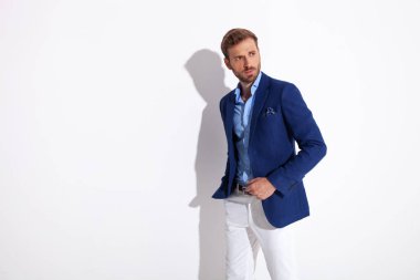 çekici bir adam el ile cebinde durur ve uzak görünüyor