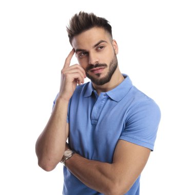 Mavi bir polo giyen genç düşünceli bir adam portresi