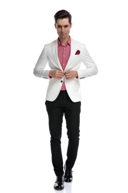 Genç serin kadar ceketinin düğmelerini ve yürüme zarif adam