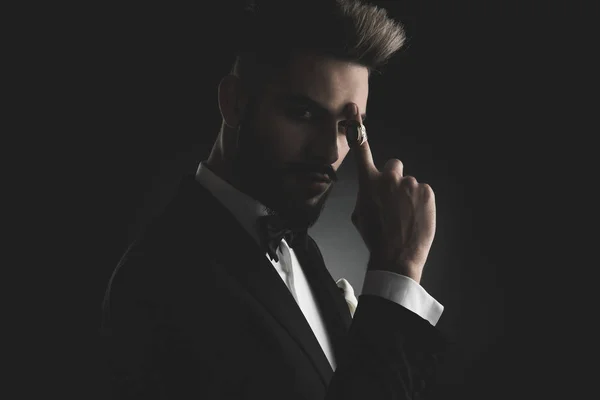 Man in tuxedo poiting his finger to forehead — Stock Photo, Image