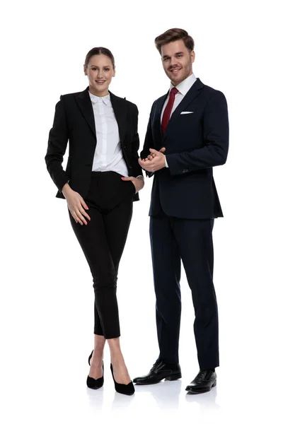 Пара в деловых костюмах, стоящая с поднятыми руками — стоковое фото