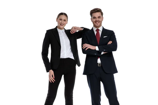 Paar im Businessanzug steht mit Ellbogen auf Schulter gestützt — Stockfoto