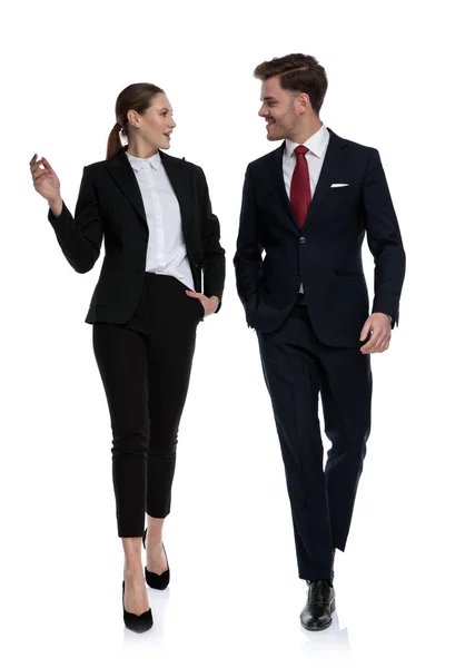 Пара в деловых костюмах ходить и говорить — стоковое фото