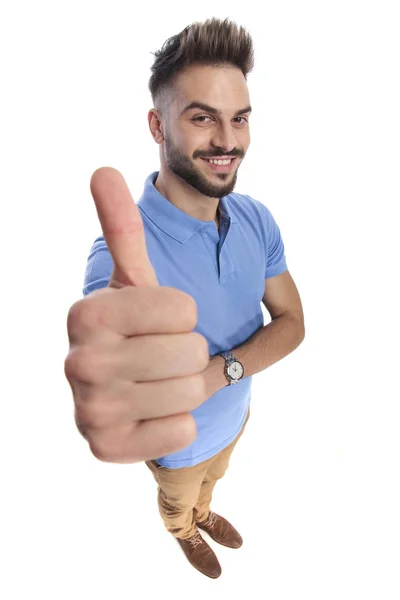 Casualmente vestido homem sorrindo mostrando um sinal de polegares para cima — Fotografia de Stock