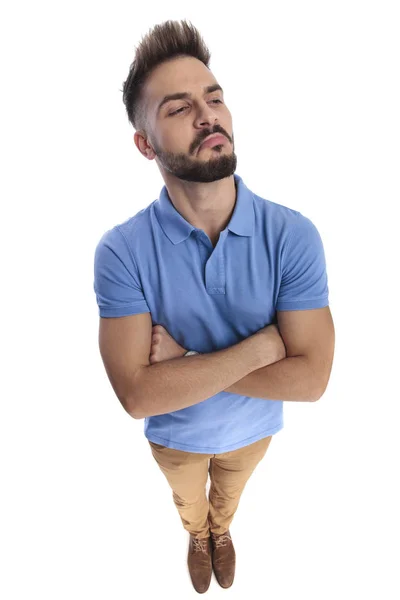Молодой привлекательный мужчина в светло-голубом поло смотрит в сторону — стоковое фото