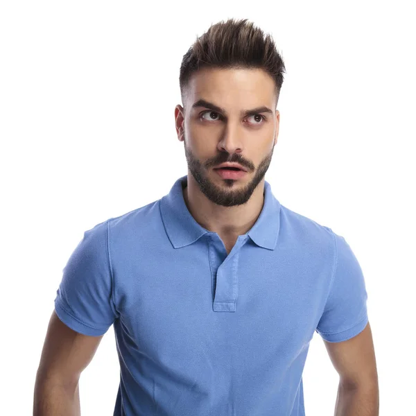 Giovane uomo che indossa una polo azzurra cercando di ricordare qualcosa — Foto Stock