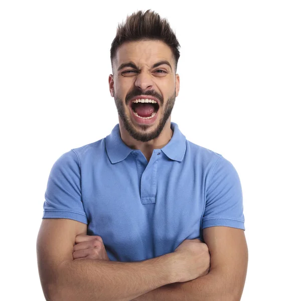 Angry young man wearing a light blue polo shouting out loud — Stock Photo, Image