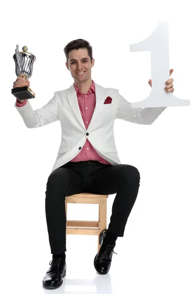 Jovem empresário elgant bem sucedido segurando troféu e número em — Fotografia de Stock
