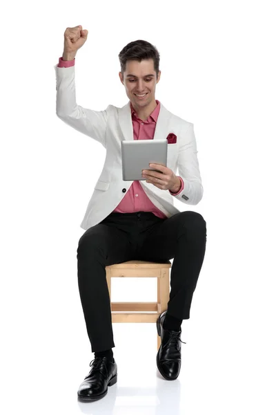 Zarif adam oturmuş ve onun tablet iyi haber okuma — Stok fotoğraf