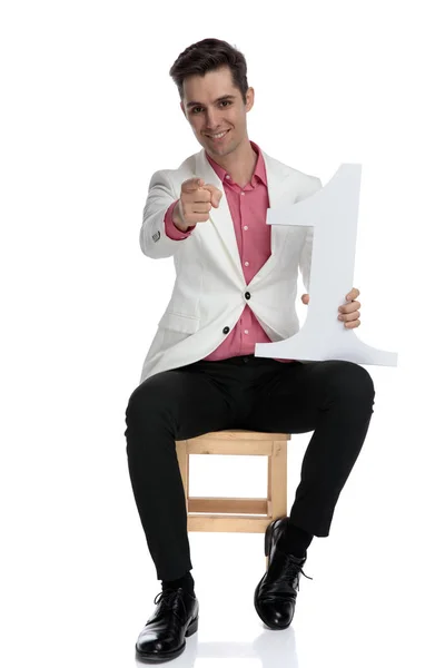 Lächelnd sitzender eleganter Mann, der dich zur Nummer eins wählt — Stockfoto