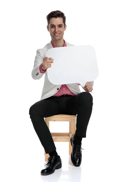 Sorrindo homem casual inteligente segurando bolha de fala está apontando fing — Fotografia de Stock