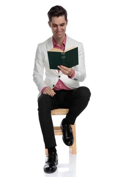 Jonge elegante student lezen van een boek zittend — Stockfoto