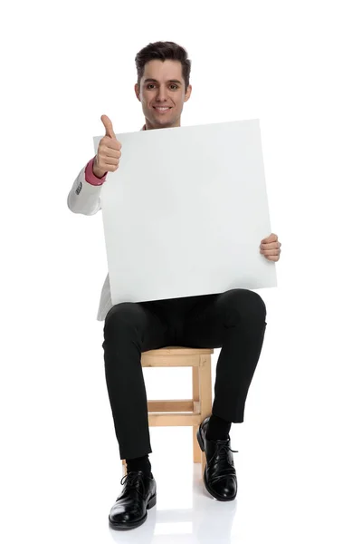 Sitzender Geschäftsmann mit leerer Tafel macht das Okay-Zeichen — Stockfoto