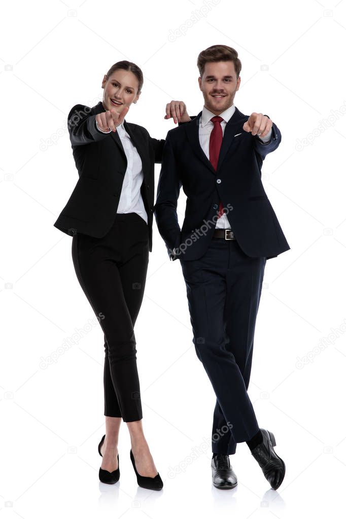 couple in business suits pointing