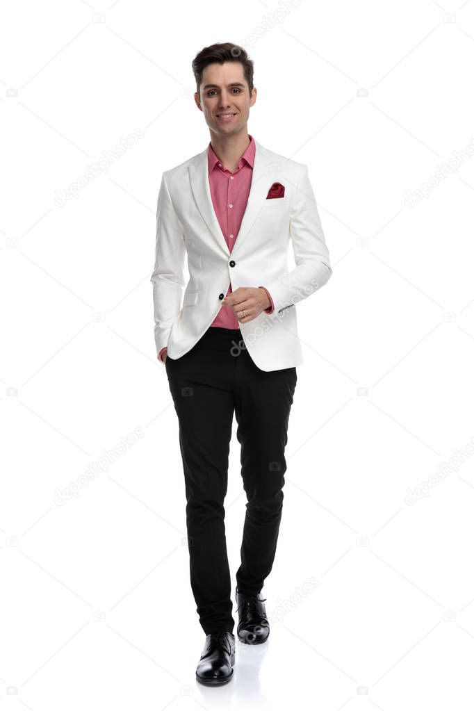 relaxed young business man is walking with  hand in pocket
