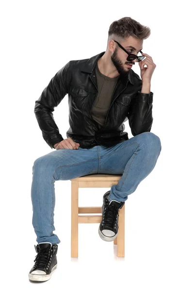 Man adjusting his sunglasses while looking away — Stock Photo, Image