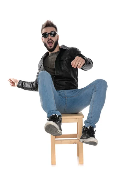 Людина в чорній куртці і блакитні джинси падають зі стільця — стокове фото