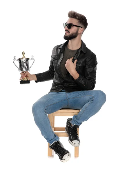 Hombre con copa de trofeo en la mano ajustando su cuello — Foto de Stock