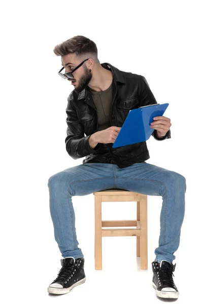 Hombre señalando su dedo en la carpeta azul explicando — Foto de Stock