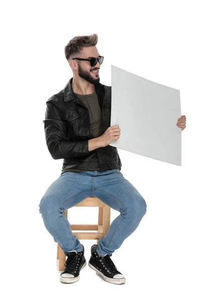 Hombre mostrando un cartel en blanco mientras sonríe —  Fotos de Stock
