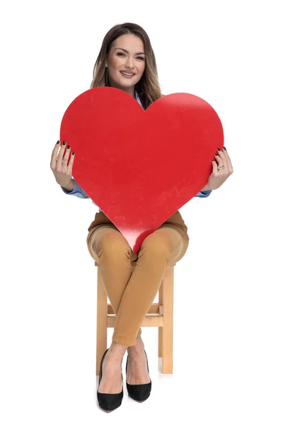 Junge smarte, lässige Frau hält großes Valentinstag-Herz — Stockfoto