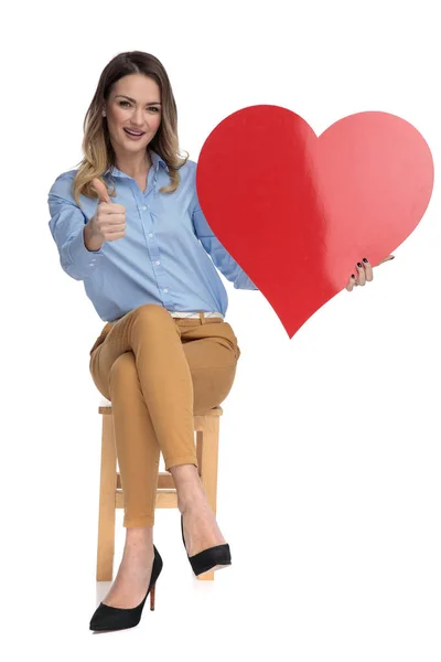 Giovane donna intelligente casual tiene grande cuore di San Valentino — Foto Stock