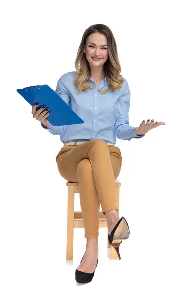 Zvědavý sedící smart casual žena drží schránky ve vzduchu — Stock fotografie
