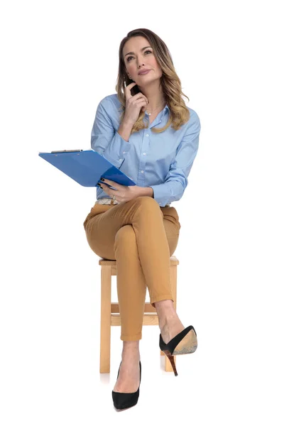 Young smart casual woman sits and speaks on the phone — Stock Photo, Image