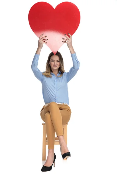 Glückliche Geschäftsfrau hält rotes Herz in die Luft — Stockfoto