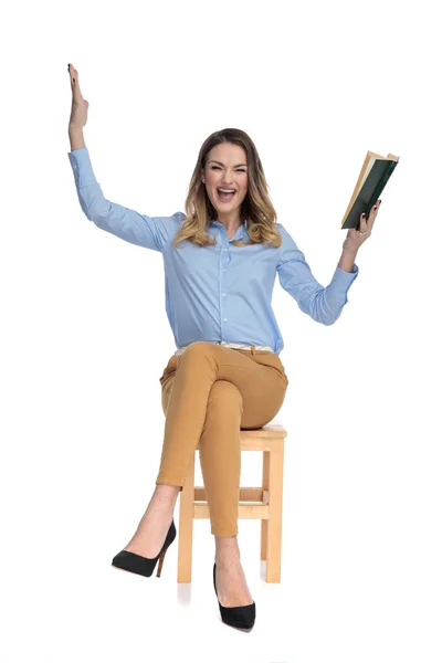 Excitada mujer de negocios casualmente vestida celebra mientras sostiene —  Fotos de Stock