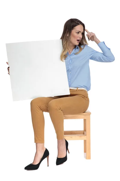 Young businesswoman holds a blank billboard just remembered some — Stock Photo, Image