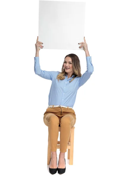 Atraente mulher casual inteligente detém placa branca no ar — Fotografia de Stock