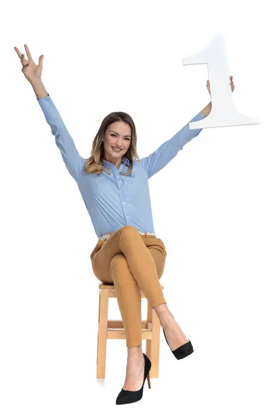 Businesswoman sits on chair and celebrates first place — Stock Photo, Image