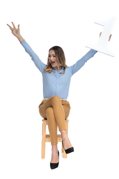 Businesswoman sits on chair and celebrates first place — Stock Photo, Image