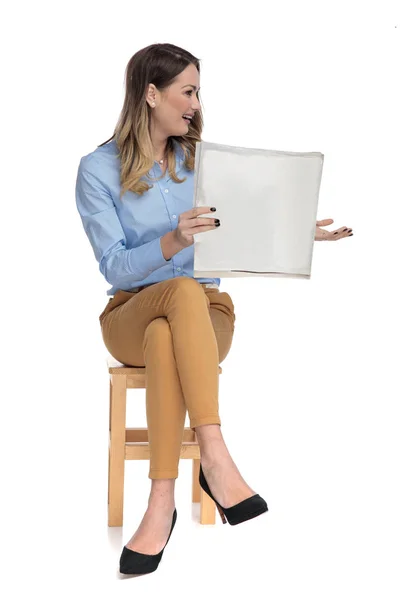 Businesswoman relaxing on wooden chair holds a newspaper — Stock Photo, Image