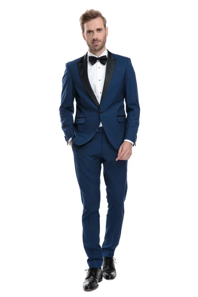 Bruidegom kerel in blauwe tuxedo wandelen met hand in de zak — Stockfoto