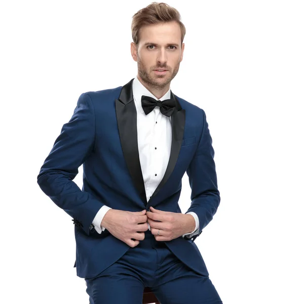 Luxe man zijn lounge jas dichtknopen zittend — Stockfoto
