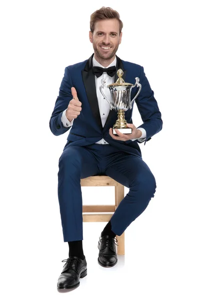 Gentleman showing ok gesture while holding a trophy cup — Stock Photo, Image