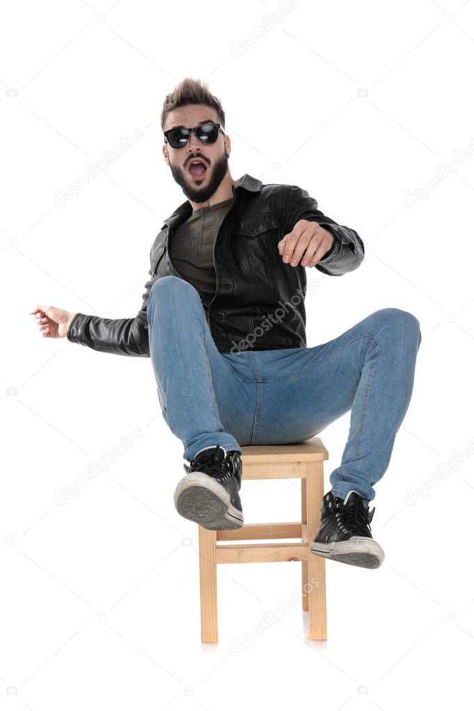man in black jacket and blue jeans falling from chair