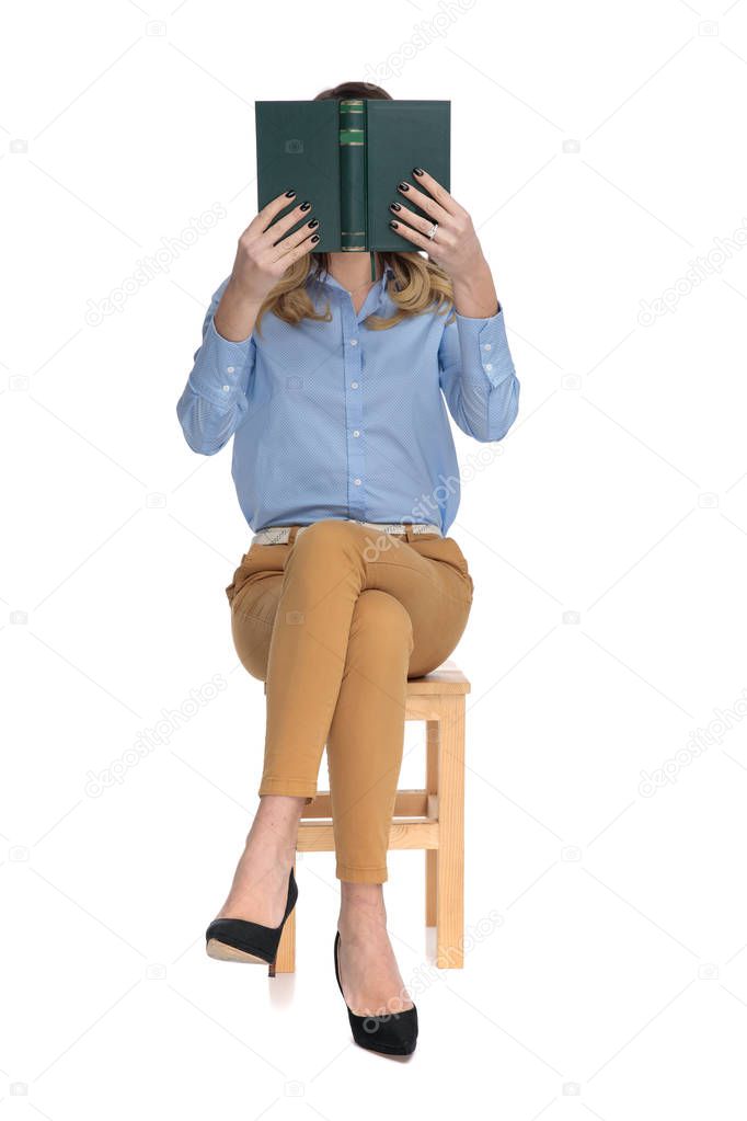 captivated smart casual woman reading while sitting
