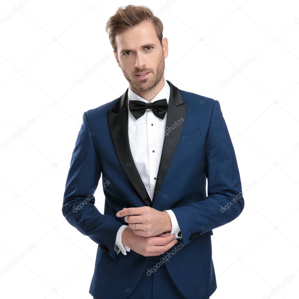 married man in blue suit adjusting his sleeve